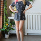 Heimish Full Size Star Print Asymmetrical Neck Short Sleeve Top - Farnelli