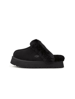 Black UGG Womens Disquette footwear featuring a sleek design and comfortable fit, shown on a model.