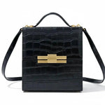 Leather Nina cigar box bag by thebagicon with a structured rectangular shape and metal clasp closure.