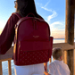 Baldwin Baby Company Daphne diaper bag in crimson shown in a sunset lifestyle setting