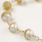 Adjustable bracelet with baroque pearls wrapped in delicate gold mesh netting connected by textured chain links
