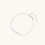 Minimalist bracelet with iridescent baroque pearl on rhodium-plated sterling silver chain against cream background