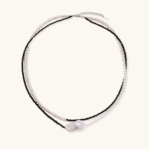 Double-strand necklace with black faceted quartz and white pearls featuring an oversized baroque pearl centerpiece