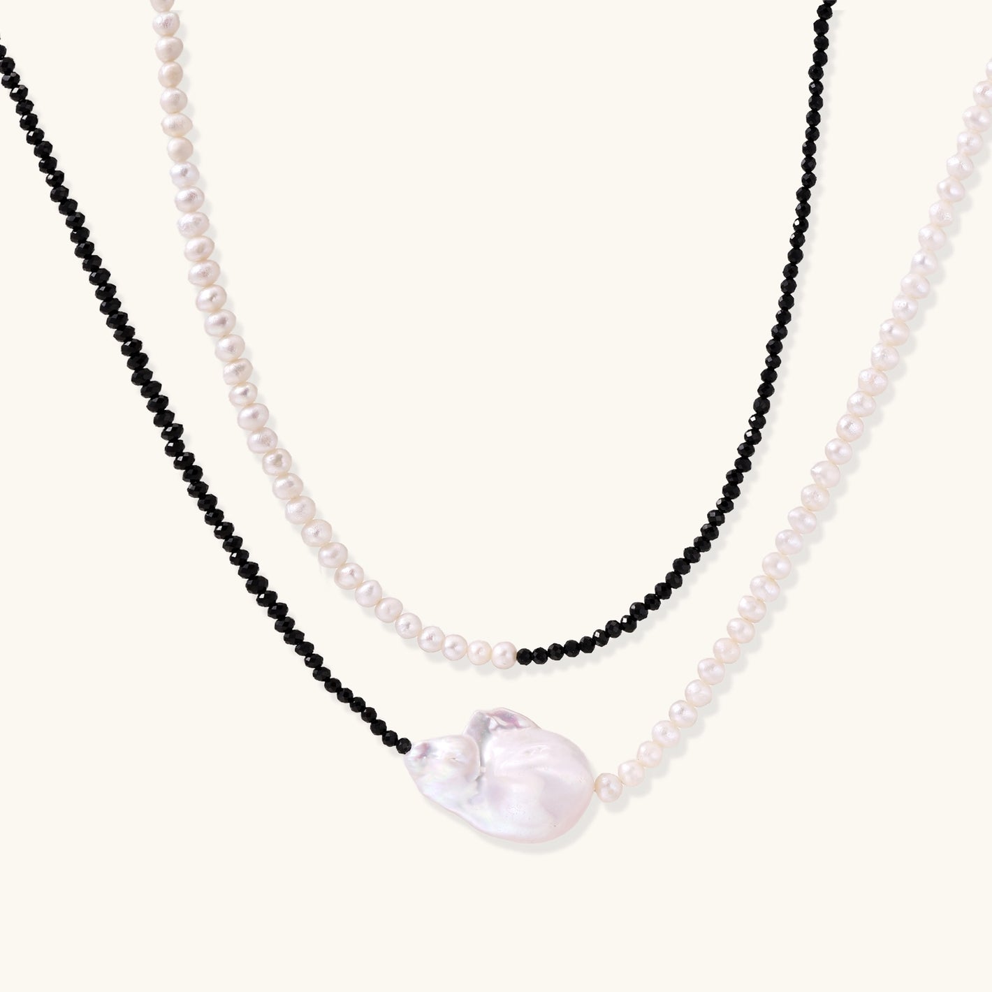 Double-strand necklace with black faceted quartz and white pearls featuring an oversized baroque pearl centerpiece