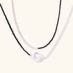 Double-strand necklace with black faceted quartz and white pearls featuring an oversized baroque pearl centerpiece