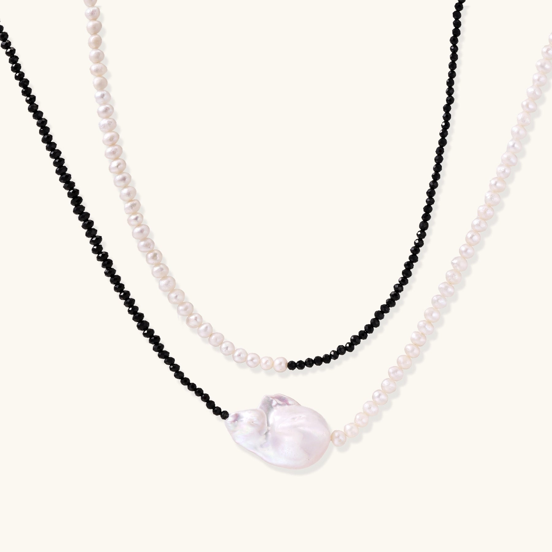 Double-strand necklace with black faceted quartz and white pearls featuring an oversized baroque pearl centerpiece