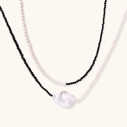 Double-strand necklace with black faceted quartz and white pearls featuring an oversized baroque pearl centerpiece