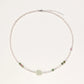 Delicate pearl necklace with pale green serpentine jade centerpiece and colorful agate beads on cream background