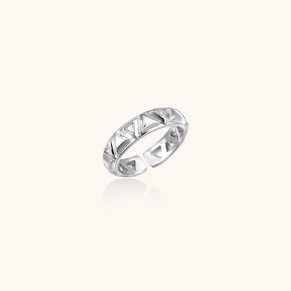 White gold adjustable ring with geometric triangle cutouts and zirconia stones on cream background