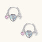 Silver chain hoop earrings with iridescent opal heart charms and pink zirconia accents on white background