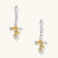 Ornate gold plated cross drop earrings with rose details and sparkling zirconia stones on white background.
