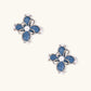 Blue denim fabric flower studs with white gold plated petals, pearl center, and zirconia accents on white background