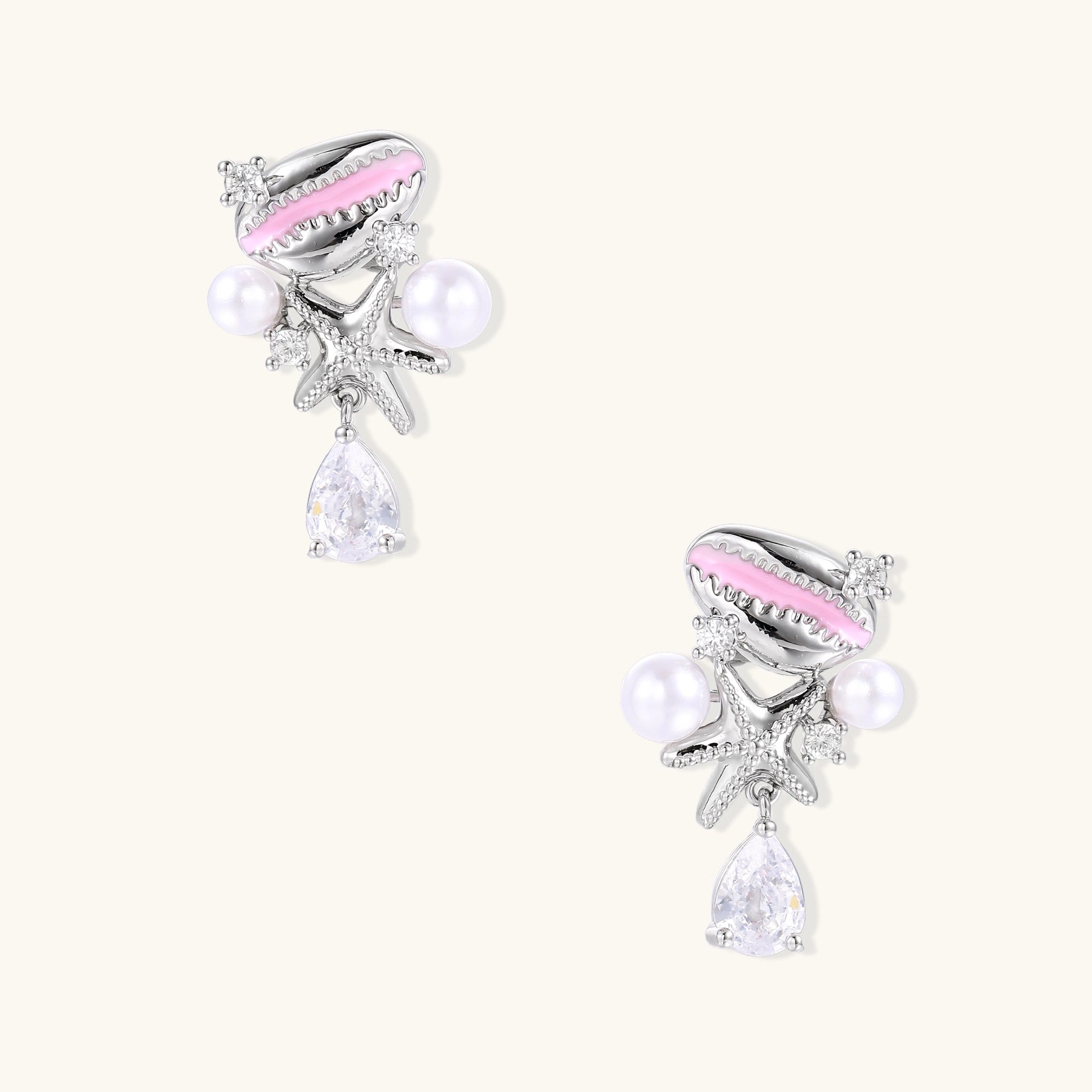 Coastal earrings with enamel cowrie shell, white pearls, starfish charm, and teardrop crystal on silver-toned metal