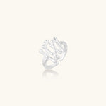 Sculptural sterling silver ring with organic branch design and textured surfaces on cream background