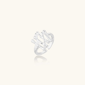 Sculptural sterling silver ring with organic branch design and textured surfaces on cream background