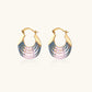 Gold hoop earrings with gradient blue-to-pink enamel in ribbed fan design on beige background