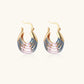 Gold hoop earrings with gradient blue-to-pink enamel in ribbed fan design on beige background