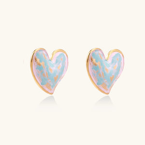 Heart-shaped stud earrings with swirled turquoise and pink enamel in gold-plated frames on cream background
