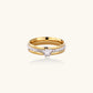 Gold-plated double-band ring with center rhinestone solitaire and channel-set stones on white background