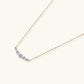 Delicate 14K gold-plated necklace with five graduated zirconia stones arranged in a curved arc on fine chain