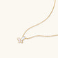 Gold-plated butterfly pendant with iridescent mother of pearl inlay on delicate chain against cream background.