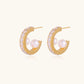 Gold pavé hoop earrings with two freshwater pearls nestled inside the curved design, featuring crystal-studded outer edge.