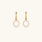 Gold-plated huggie hoop earrings with CZ-studded open circle charms on beige background