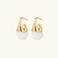 Pair of small gold-plated hoop earrings with triangular cone fronts and curved backs on white background.