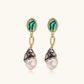 Gold drop earrings with iridescent abalone studs, rope links, jeweled caps and white baroque pearls on cream background