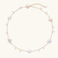 Gold vermeil chain with iridescent star-shaped baroque pearls and small round freshwater pearl drops on cream background.