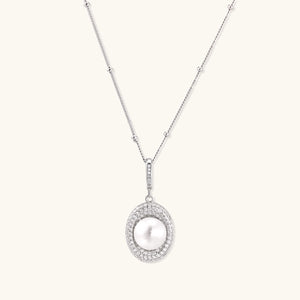 Oval sterling silver pendant with crystal halo surrounding a white freshwater pearl on delicate chain