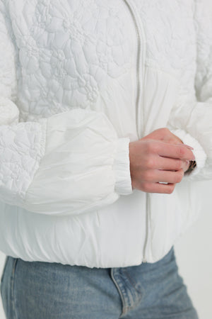 Light quilted white demi-season jacket from Alaska® Outerwear Company, showing the front view with a collar and quilted pattern.