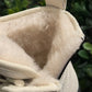 Alaska® Outerwear Company Aspen genuine shearling lined winter boots with rugged design and warm fur lining on a snowy surface.
