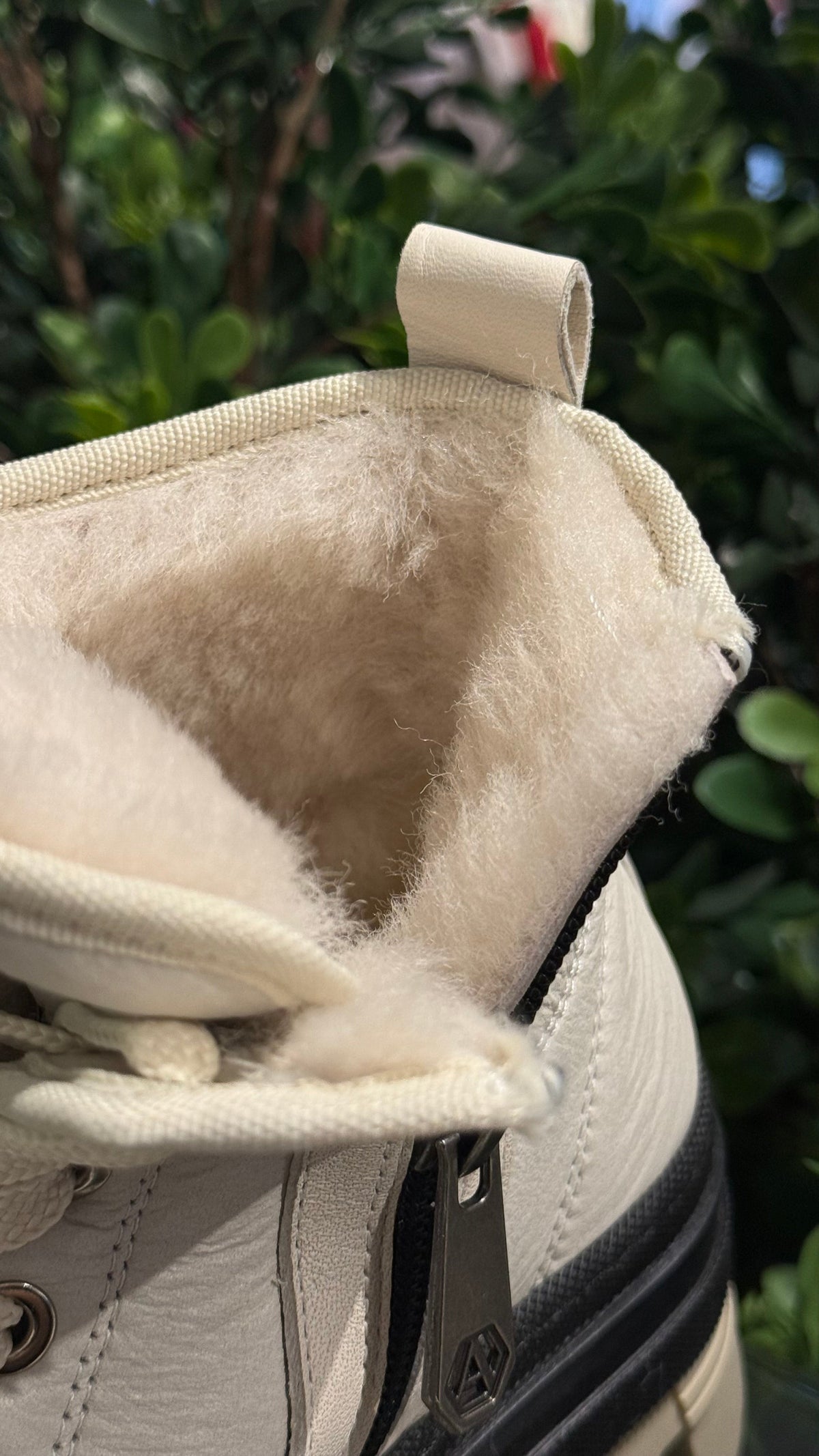 Alaska® Outerwear Company Aspen genuine shearling lined winter boots with rugged design and warm fur lining on a snowy surface.