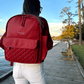 Baldwin Baby Company Daphne diaper bag in crimson, shown in a boardwalk lifestyle setting