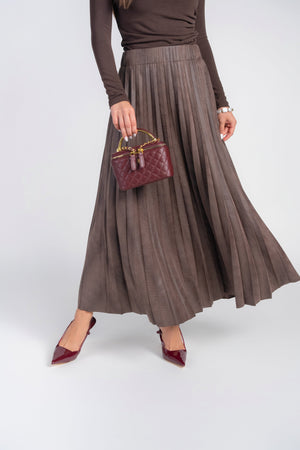 Brown pebble leather pleated maxi skirt by Adina Las Vegas, featuring a flowing silhouette and detailed pleats.