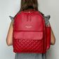 Baldwin Baby Company Daphne diaper bag in crimson, modeled view from the back
