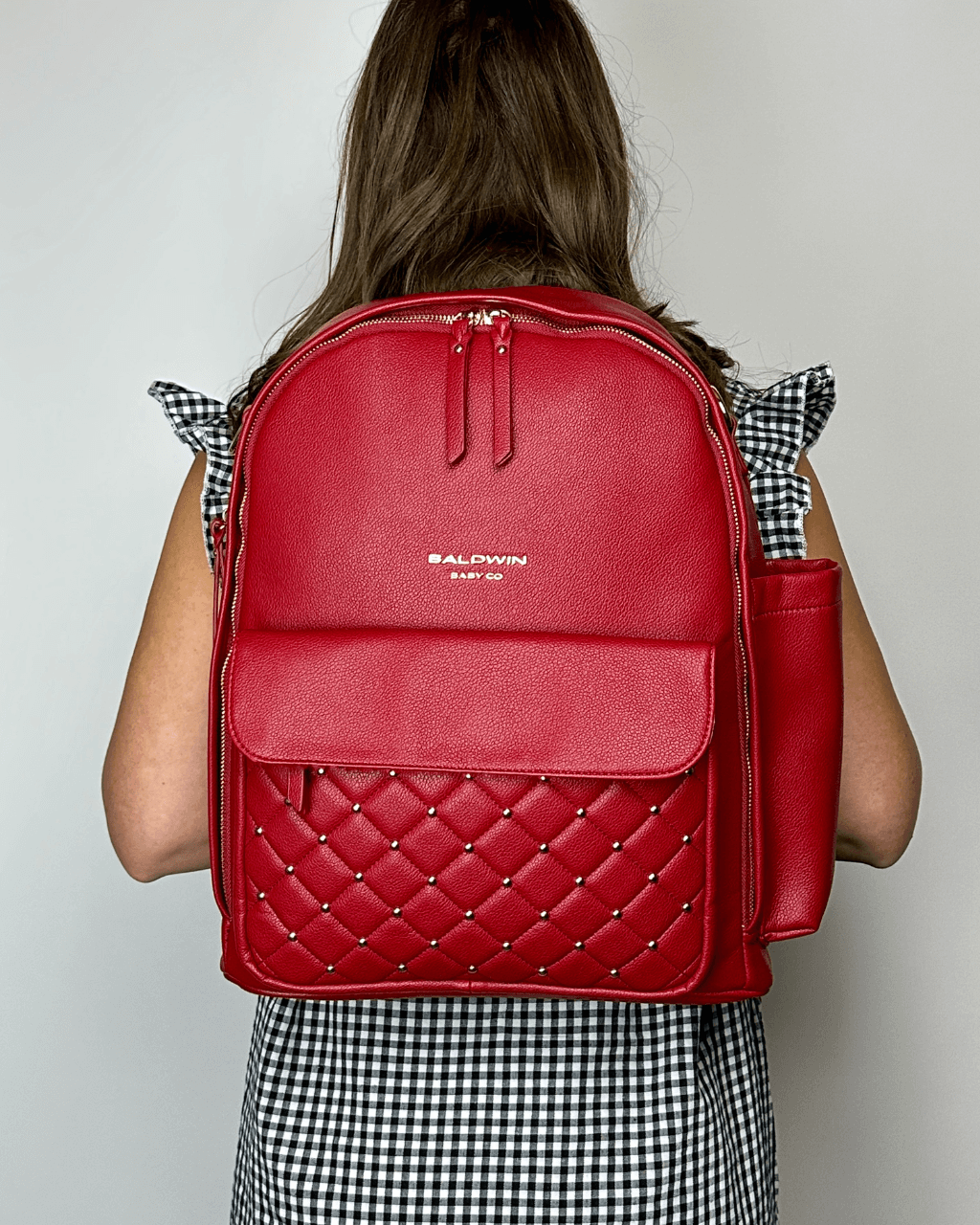 Baldwin Baby Company Daphne diaper bag in crimson, modeled view from the back