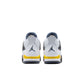 Grade school Air Jordan 4 Retro sneakers in Tour Yellow with black accents, featuring classic basketball shoe design.