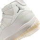 Women's Air Jordan 11 Retro Pearl sneakers in white and silver, featuring a sleek design and glossy patent leather finish.