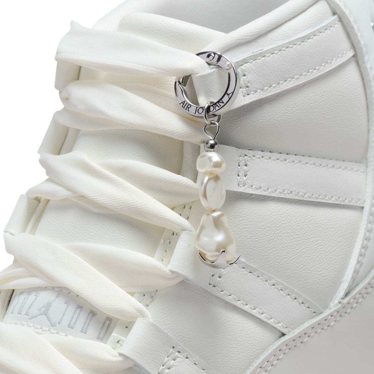 Women's Air Jordan 11 Retro Pearl sneakers featuring white patent leather and icy blue accents, stylish women's footwear by Denim Exchange.