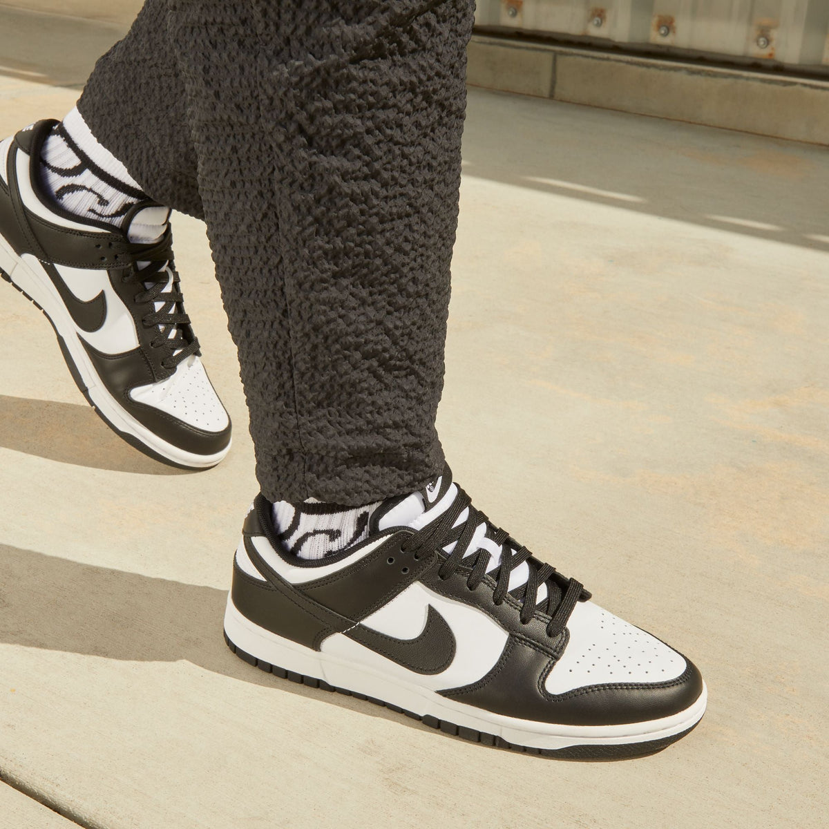 Nike men's Dunk Low Panda sneakers in white and black colorway, side view