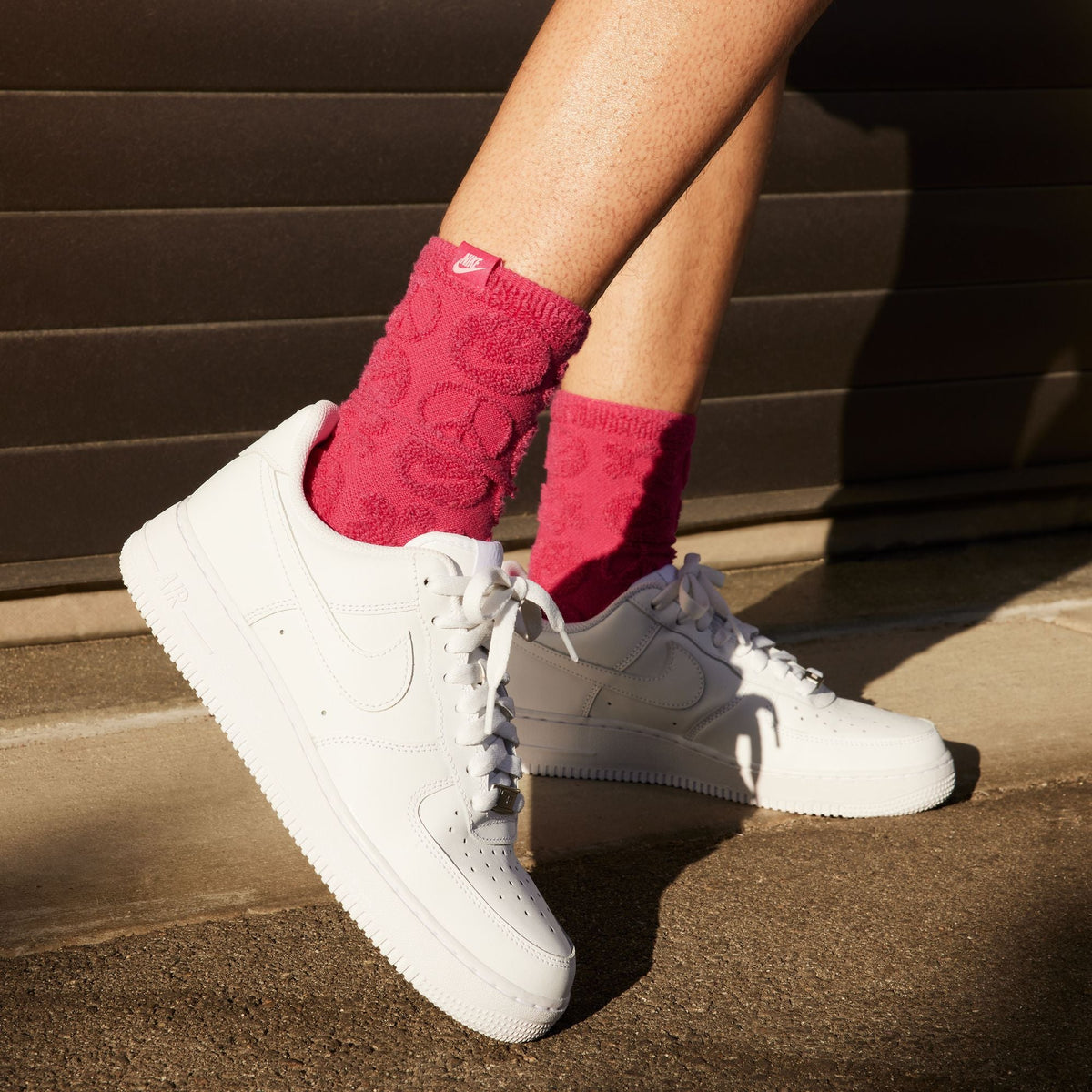 White Nike Women's Air Force 1 '07 sneakers with classic design and clean white leather, shown from a side angle.