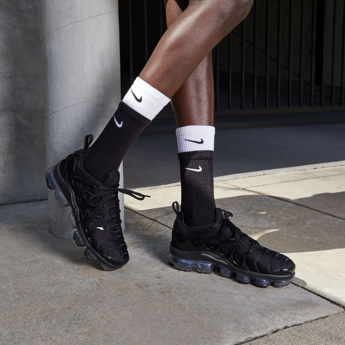 Nike Womens Air Vapormax Plus black and anthracite athletic sneakers with visible Vapormax sole in a close-up shot.