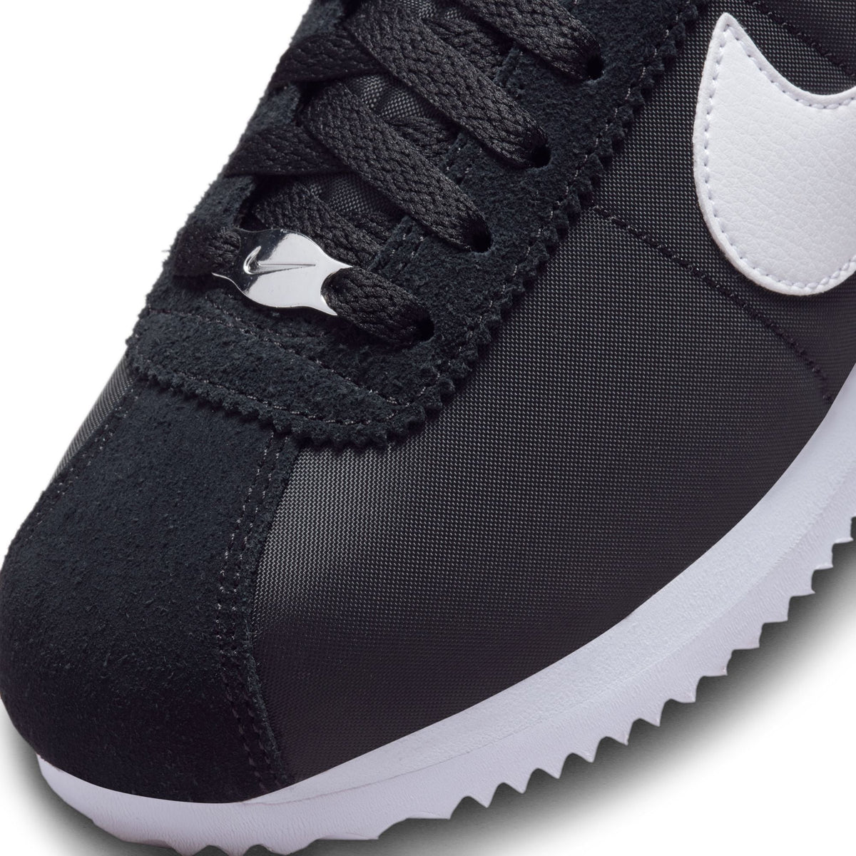 Nike Womens Cortez sneakers in black and white, showcasing classic design with white laces and Nike branding on the side.