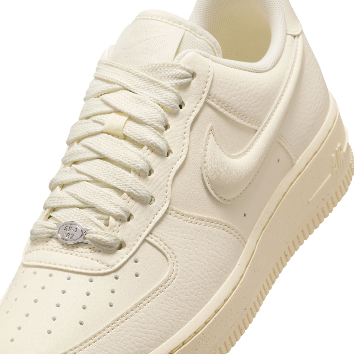 Nike Womens Air Force 1 Low sneakers in Coconut Milk color, featuring classic design and white leather upper.