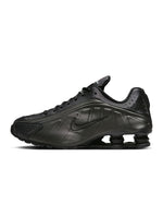 Men’s Nike Shox R4 footwear in black with signature segmented sole design