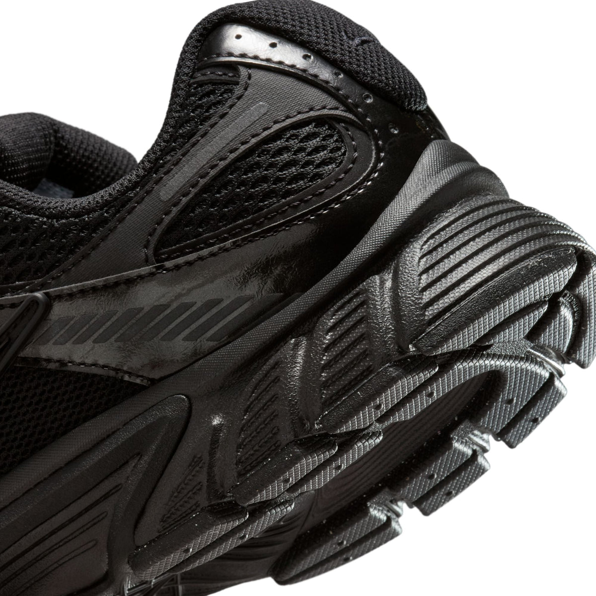 Black Nike Women's V5 RNR footwear with sleek design and Nike branding, showcased in a natural outdoor setting.