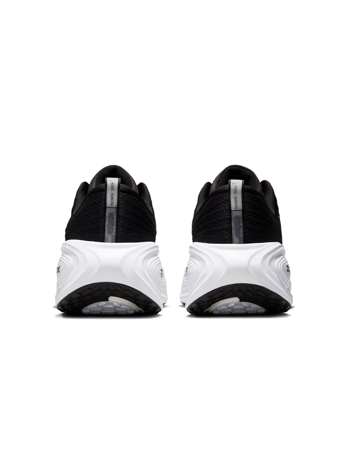 Men's Nike Vomero Plus footwear in black and white, side view with visible cushioned sole