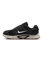 Nike men's V5 RNR black and gum color footwear, showcasing sleek design and comfortable fit in a natural outdoor setting.
